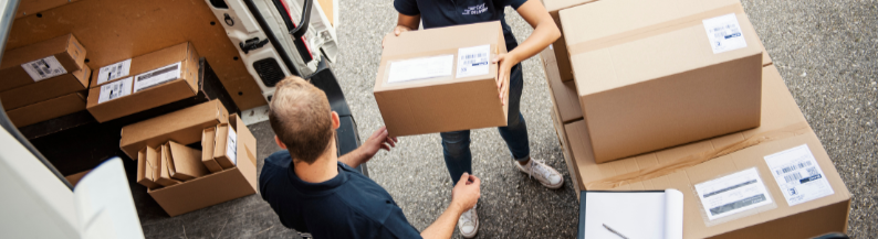 Workers handling boxes in a warehouse setting.